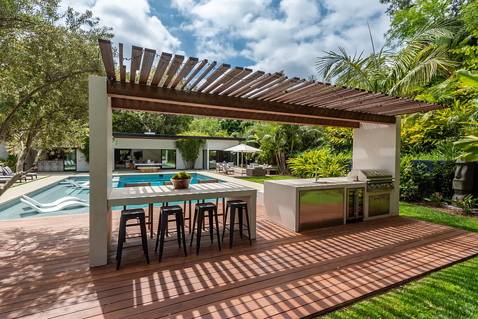 Home landscape design of outdoor kitchen by a pool