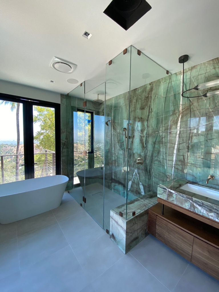 a bathroom with a large glass shower and standing tub