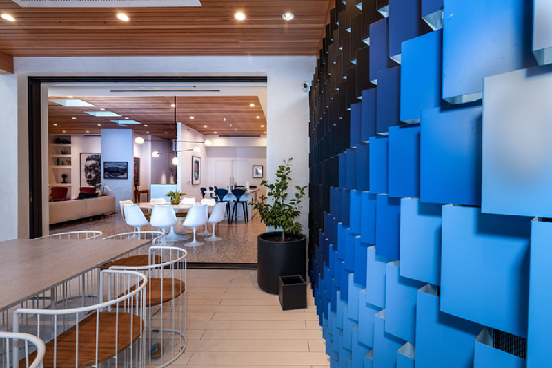a large dining area with an artistic blue accent wall