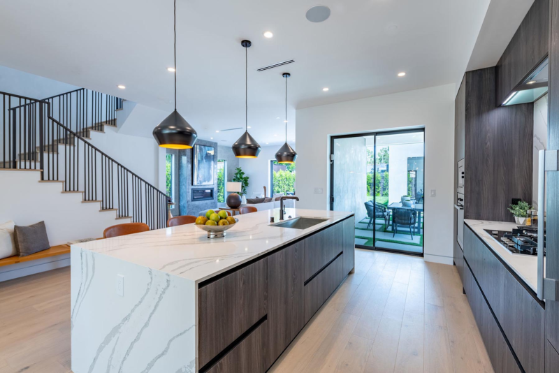 a modern kitchen island with hanging pendant lighting